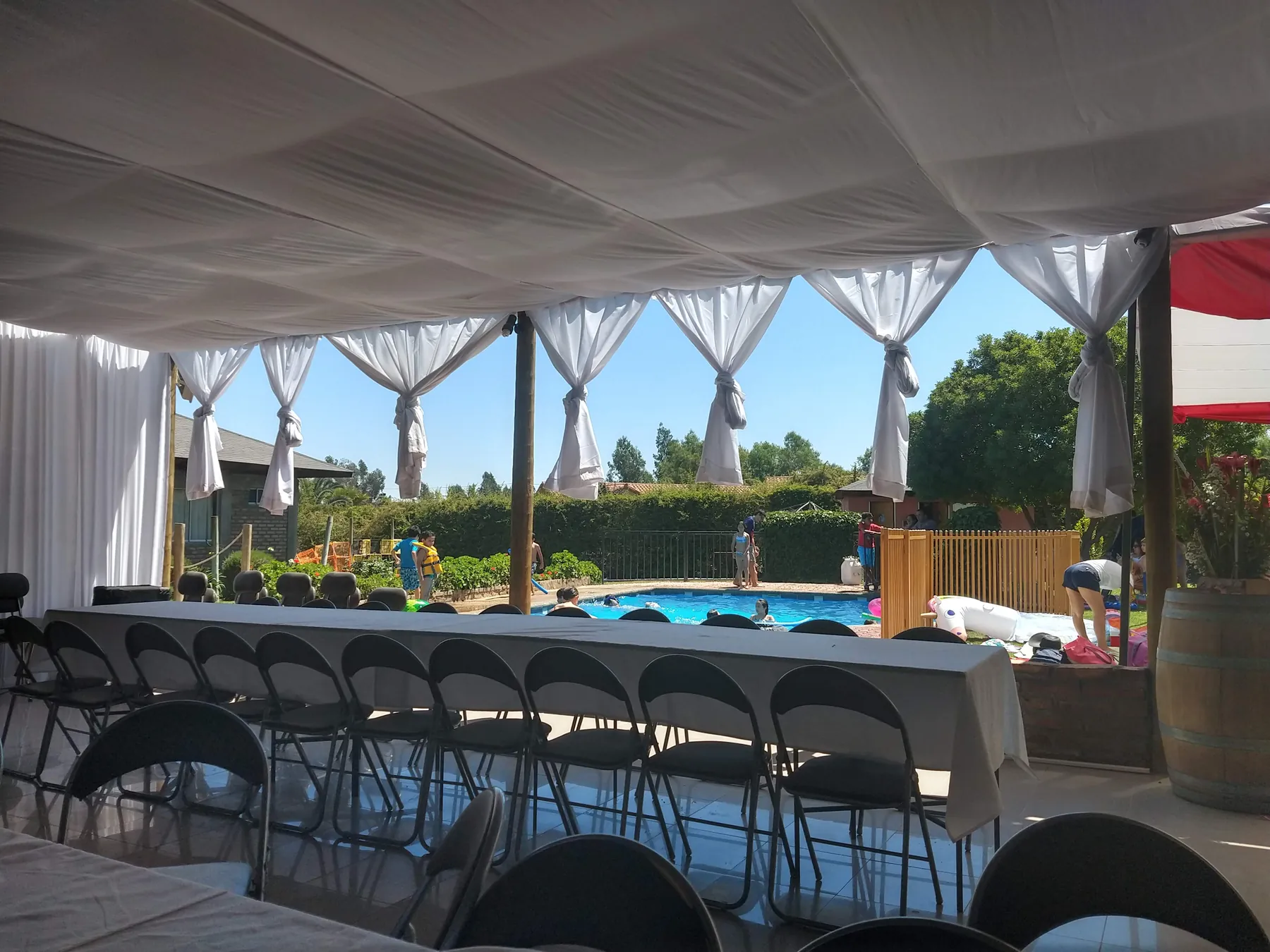 Espacio cubierto con mesas y sillas preparado para una actividad