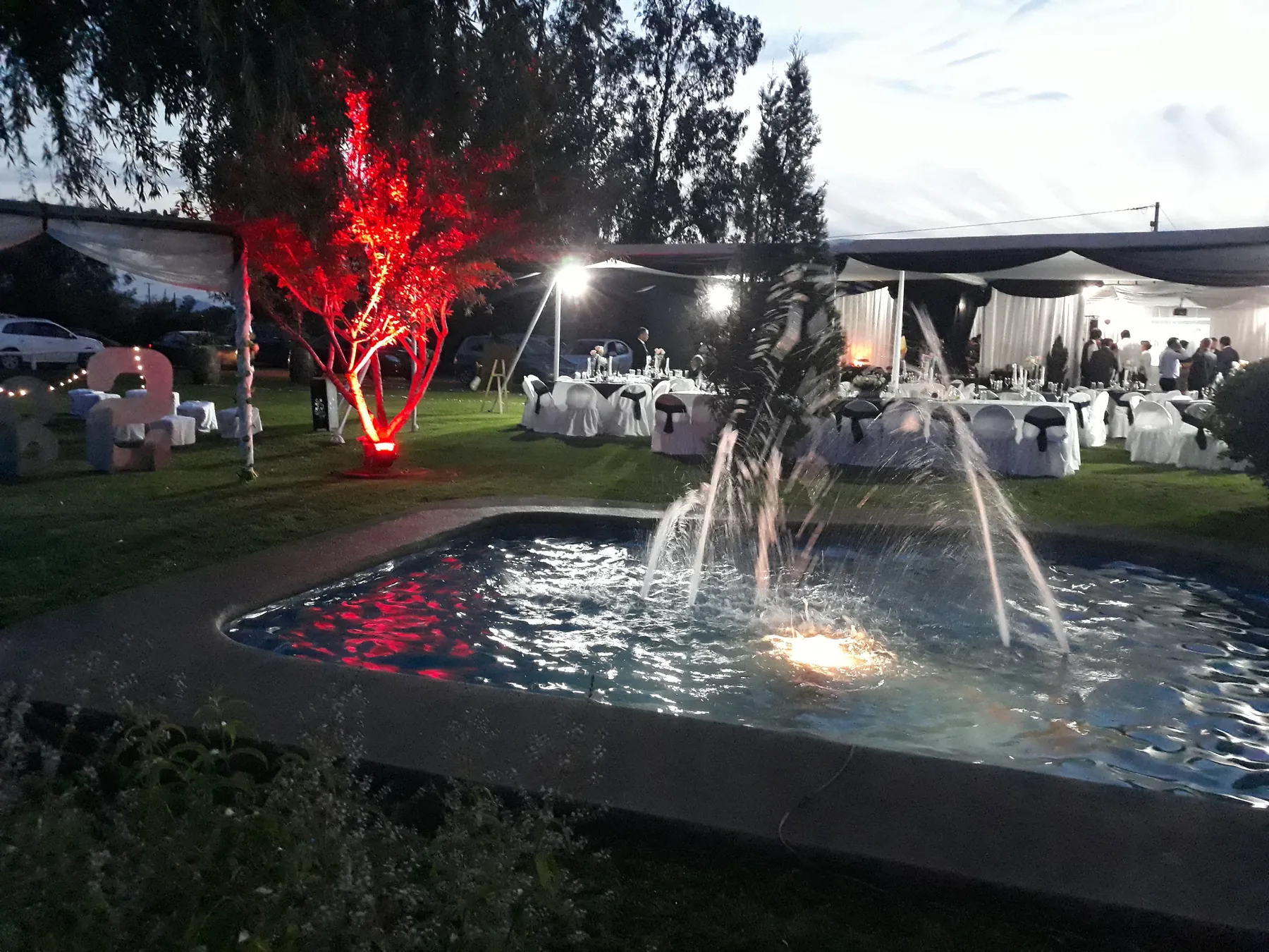 Piscina iluminada durante una celebración nocturna en Ailyn